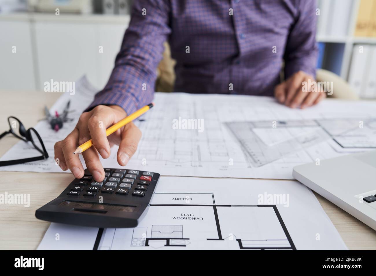 Close-up image of architect using calculator when working on construction project Stock Photo