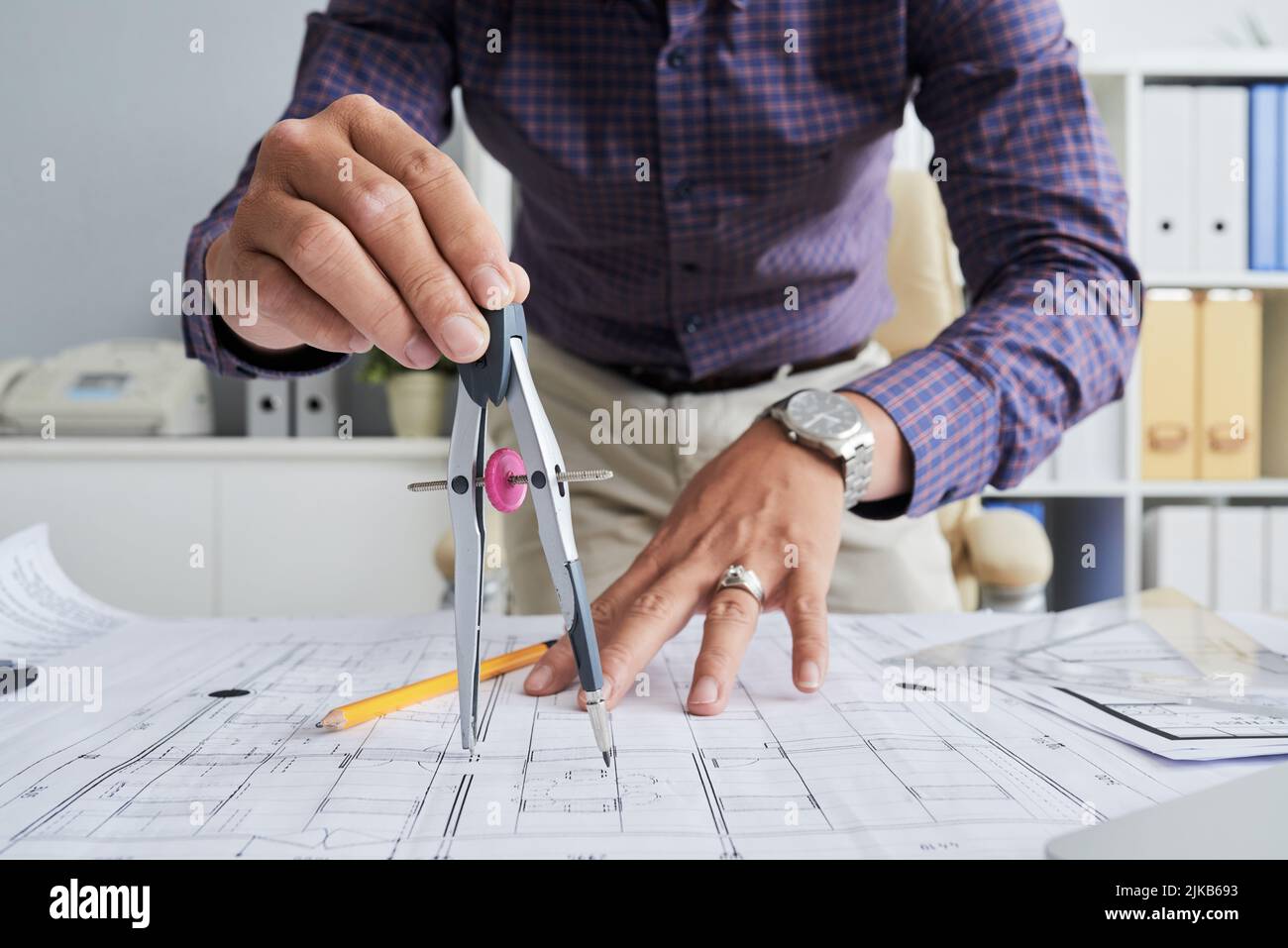 Close-up image of architect using compasses when drawing blueprint Stock Photo