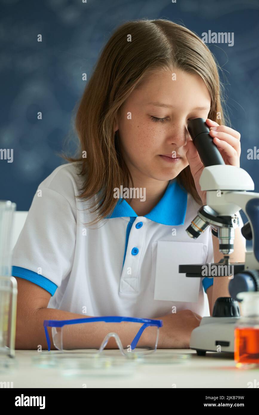 Schoolgirl looking through microscope at chemistry class Stock Photo ...