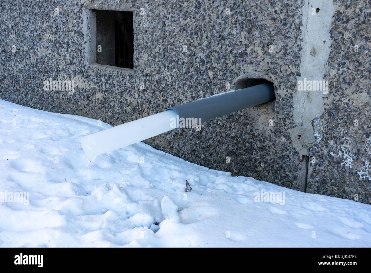 A water pipe in a house with a frozen piece of ice. rainwater