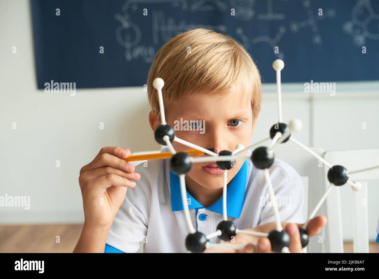 Curious kid counting atoms in molecular model Stock Photo