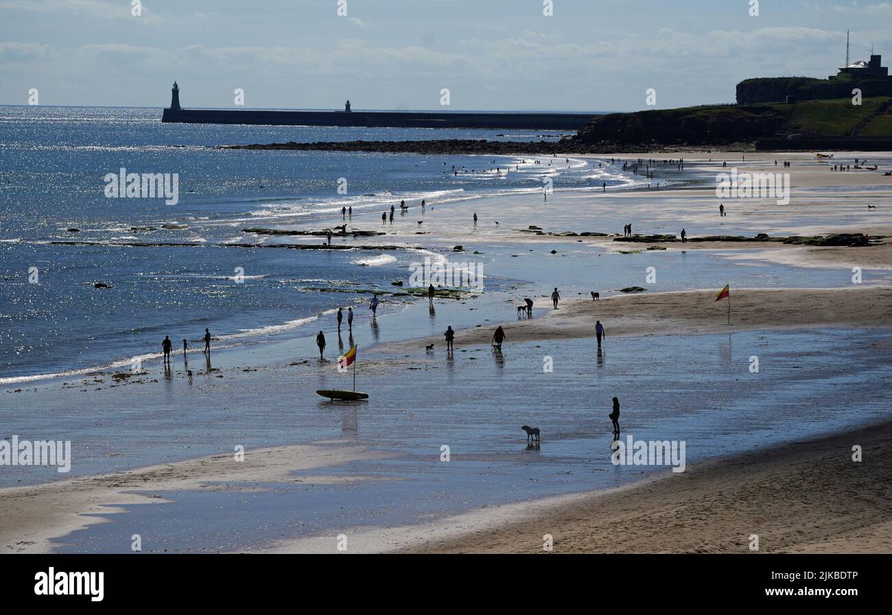People enjoying the good weather at Tynemouth beach on the North East coast as the temperature hit 22 degrees. Picture date: Monday August 1, 2022. See PA story WEATHER Summer. Photo credit should read: Owen Humphreys/PA Wire Stock Photo