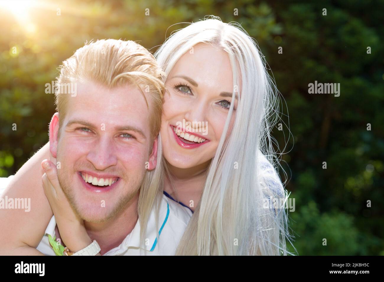 a couple in love hug each other outside in the sun Stock Photo