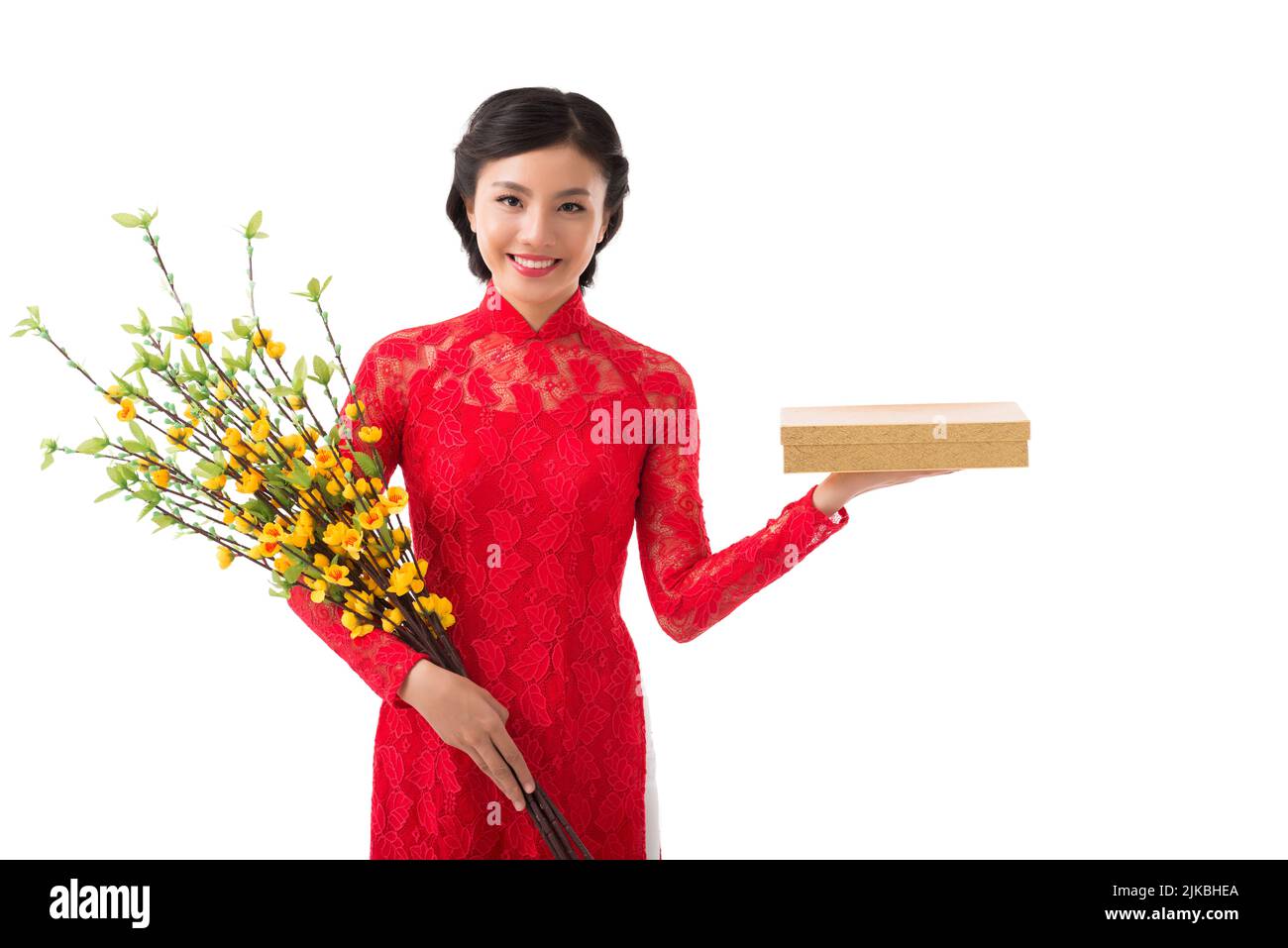 Beautiful smiling young woman with blooming apricot branches and present for Chinese New Year celebration Stock Photo