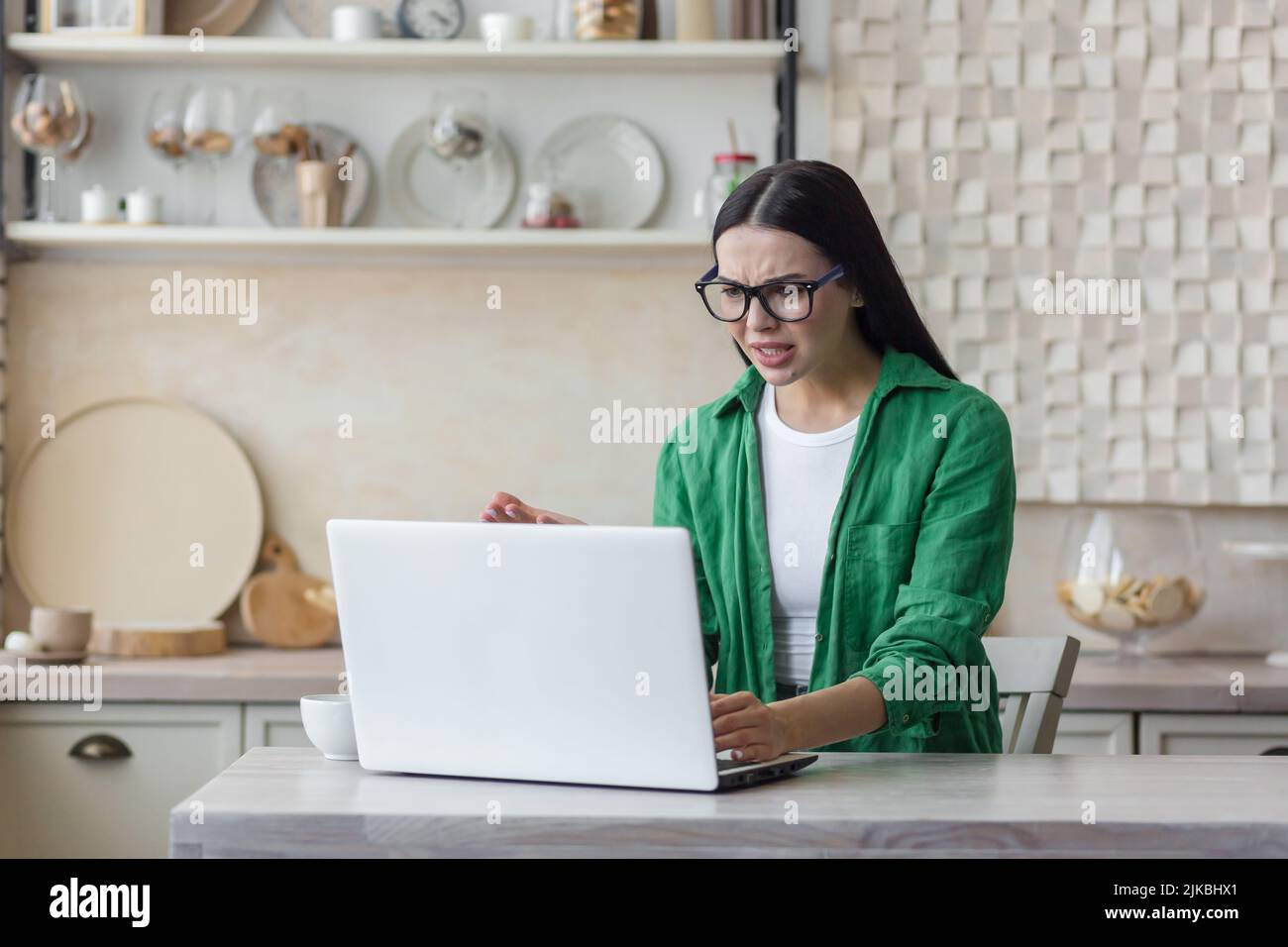 remote job, technology and people concept - tired or stressed young woman with laptop computer working at home office Stock Photo