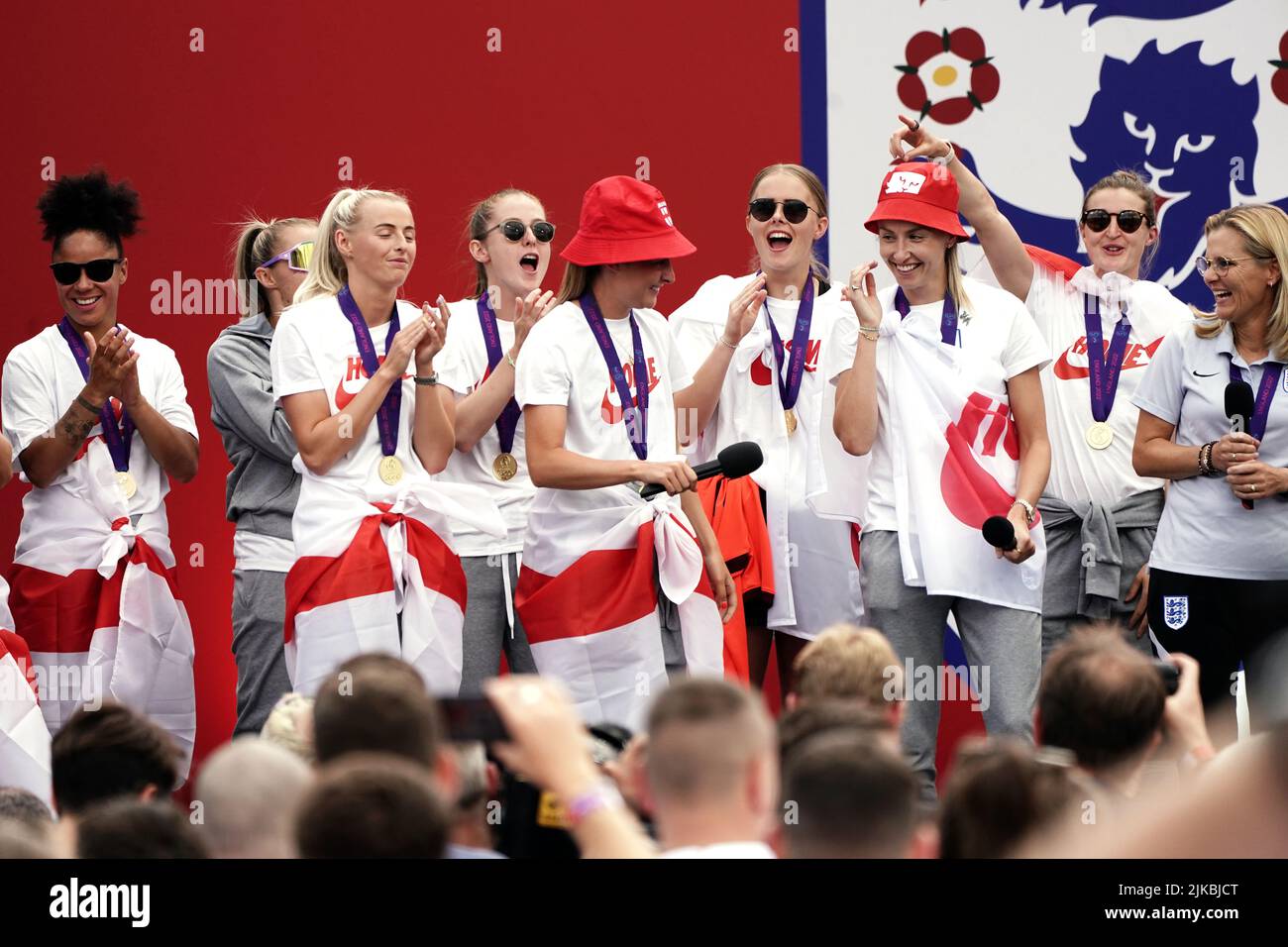 England's Ella Toone (centre, left) and Leah Williamson on stage with head coach Sarina Wiegman (right) and team mates during a fan celebration to commemorate England's historic UEFA Women's EURO 2022 triumph in Trafalgar Square, London. Picture date: Monday August 1, 2022. Stock Photo
