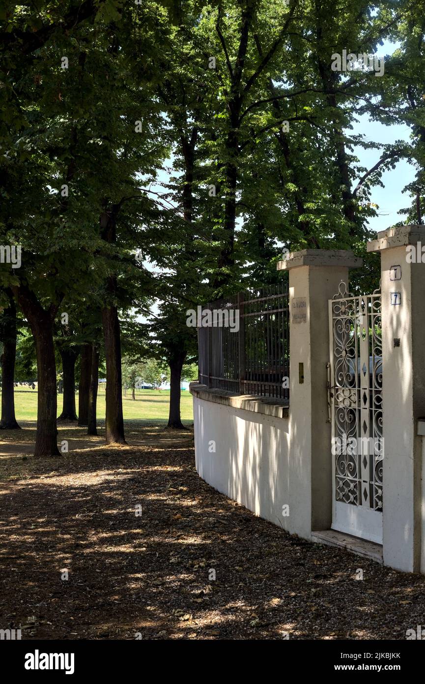 Gate and boundary wall with a fence in a park Stock Photo - Alamy