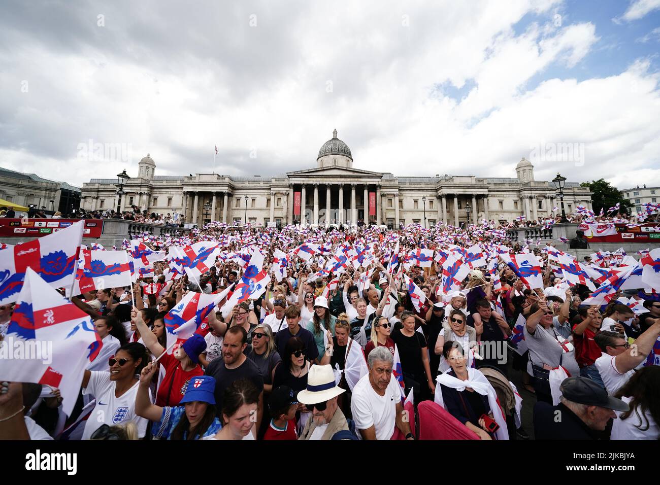 England fans wave flags during a fan celebration to commemorate England's historic UEFA Women's EURO 2022 triumph in Trafalgar Square, London. Picture date: Monday August 1, 2022. Stock Photo