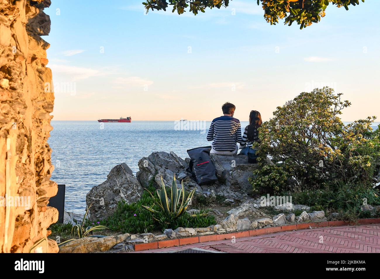A young couple from behind enjoying the view from the Anita Garibaldi Promenade at sunset, Nervi, Genoa, Liguria, Italy Stock Photo