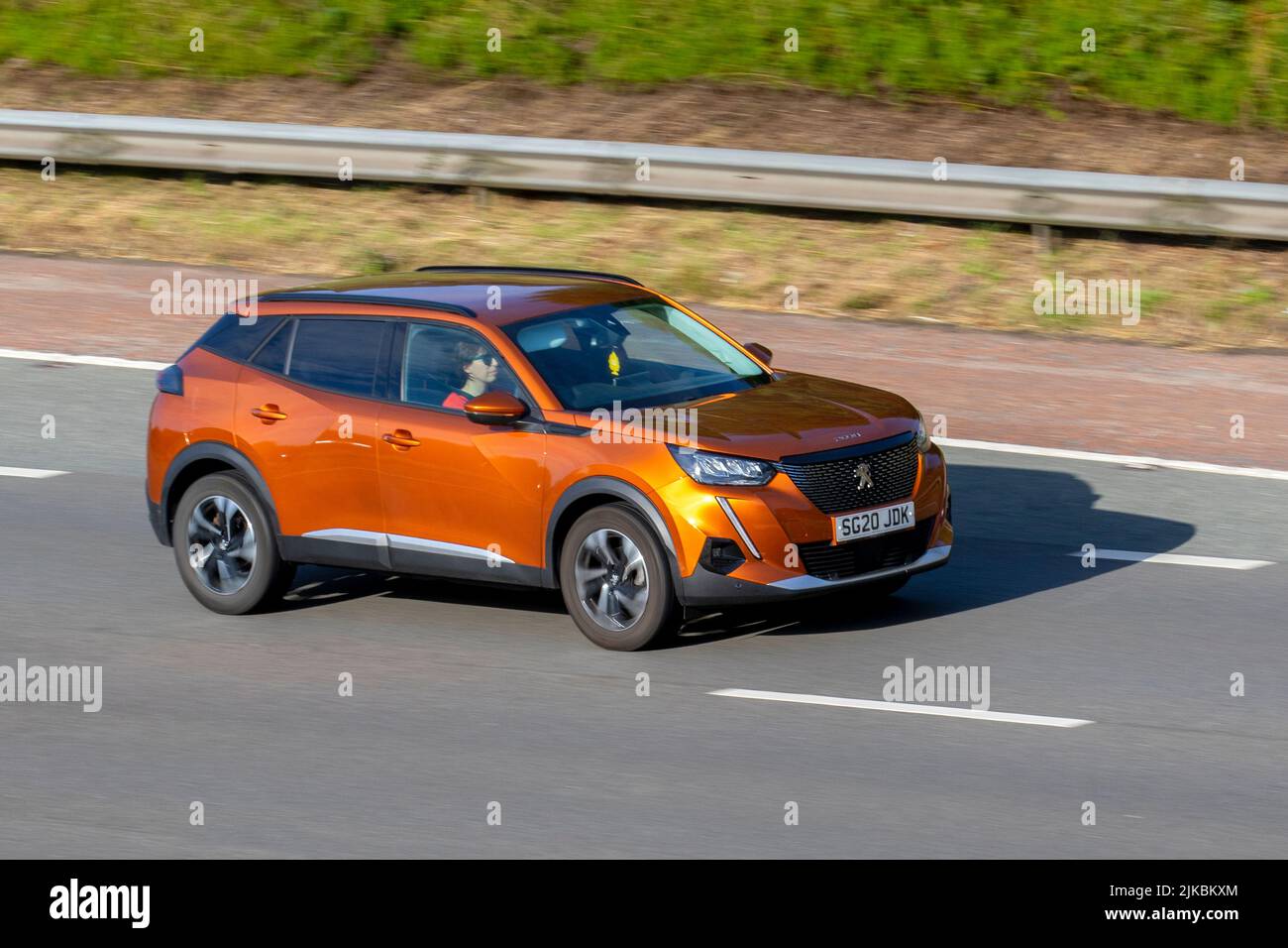 2020 orange PEUGEOT 2008 ALLURE PREMIUM PTECH S/S PURETECH Start Stop 1200cc petrol 6 speed manual; moving, being driven, in motion, travelling on the M6 motorway, UK Stock Photo