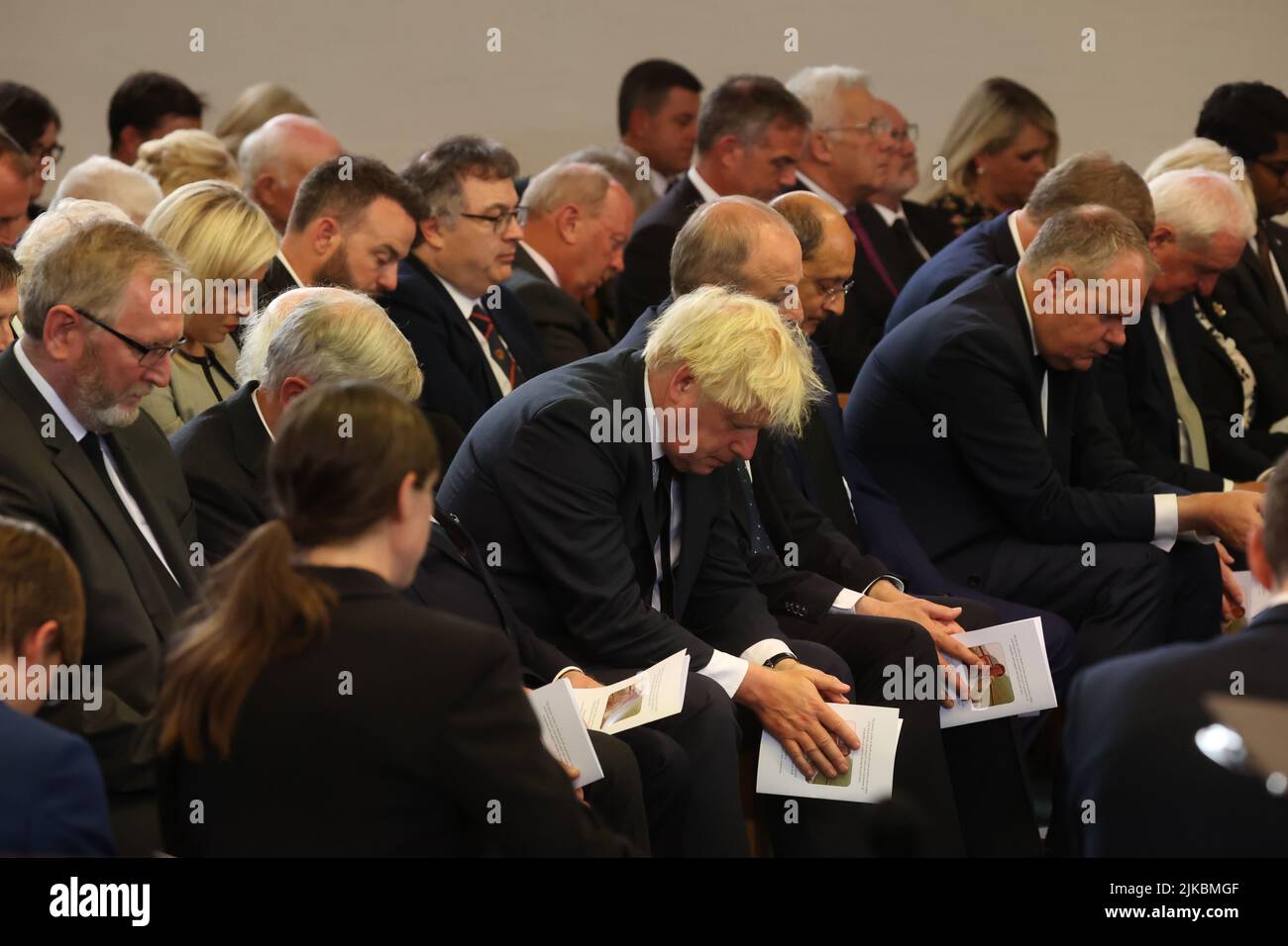 Mourners bow their heads in prayer at the funeral of former Northern