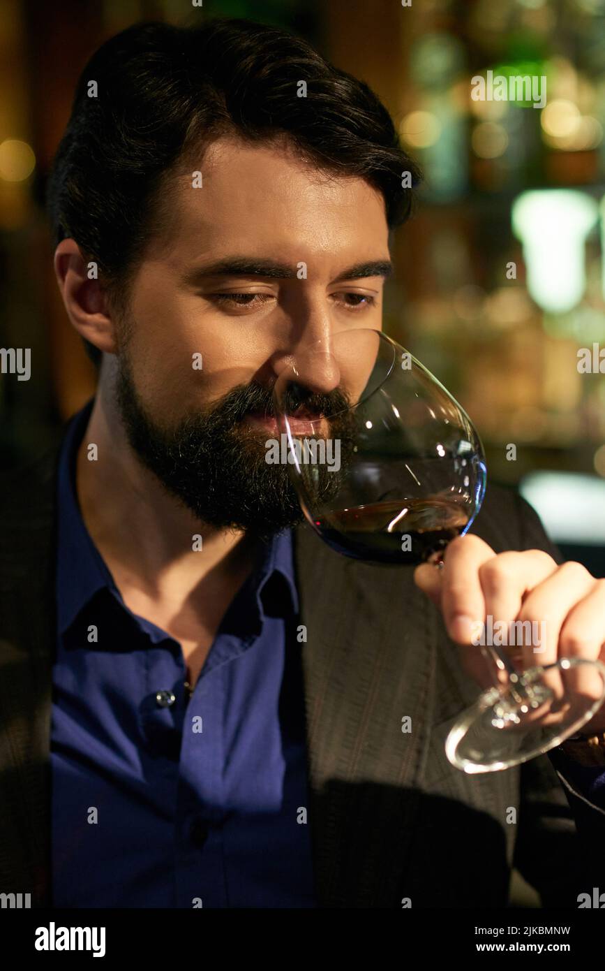 Portrait of man smelling flavor of red wine before drinking Stock Photo ...