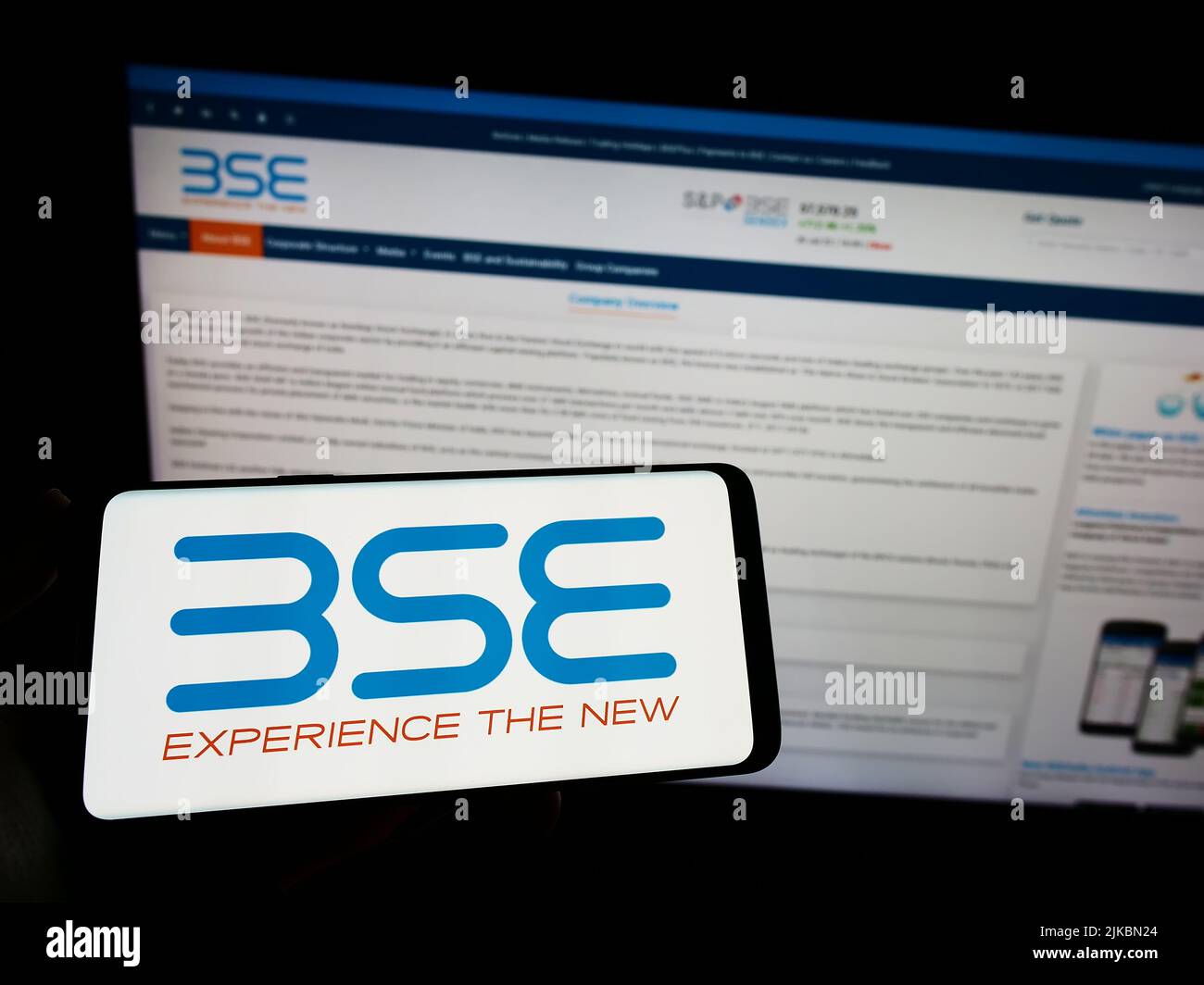 Person holding smartphone with logo of company BSE Limited (Bombay Stock Exchange) on screen in front of website. Focus on phone display. Stock Photo