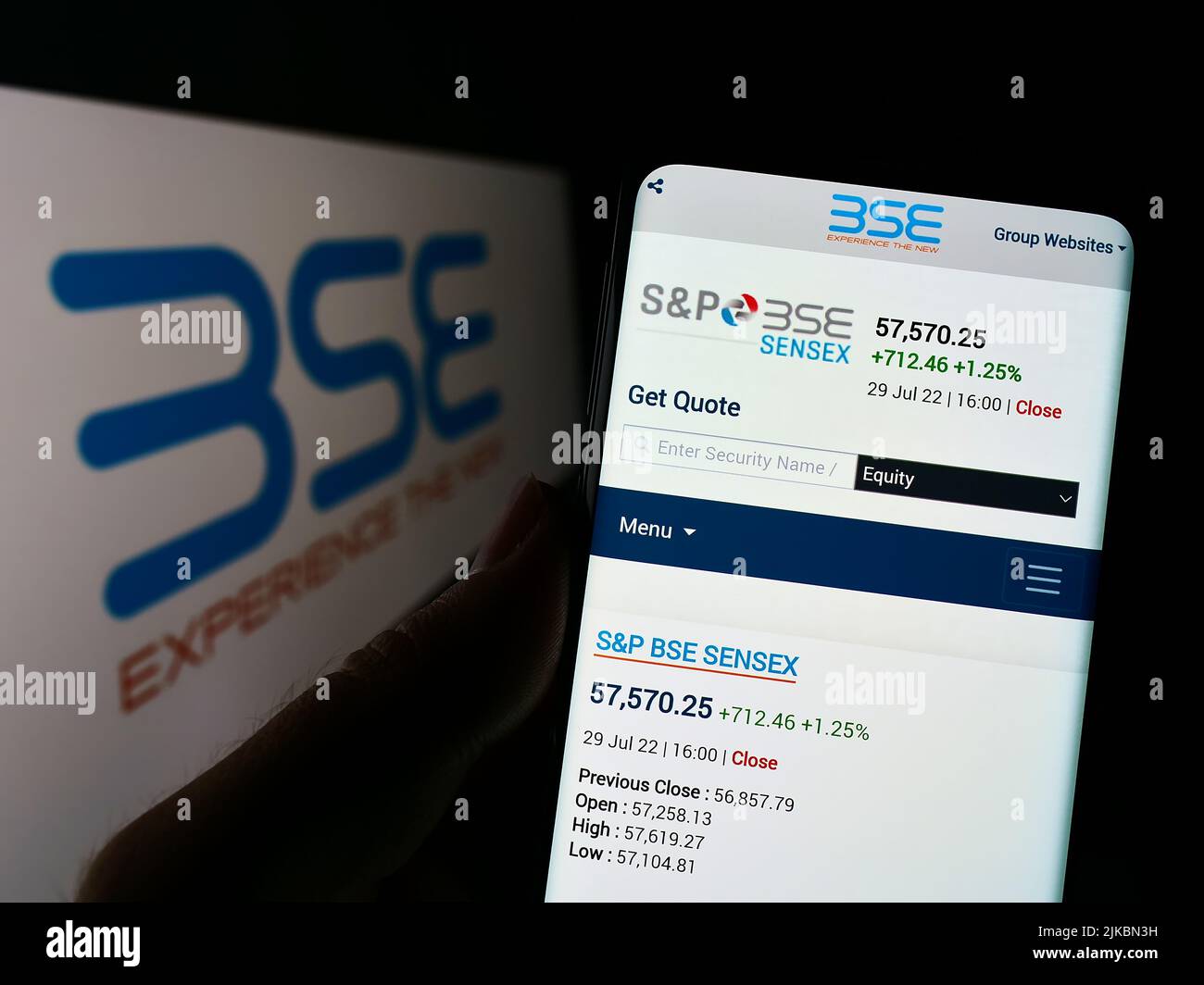 Person holding smartphone with website of company BSE Limited (Bombay Stock Exchange) on screen with logo. Focus on center of phone display. Stock Photo