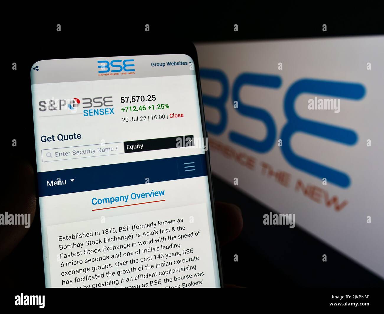 Person holding mobile phone with webpage of company BSE Limited (Bombay Stock Exchange) on screen with logo. Focus center of on phone display. Stock Photo