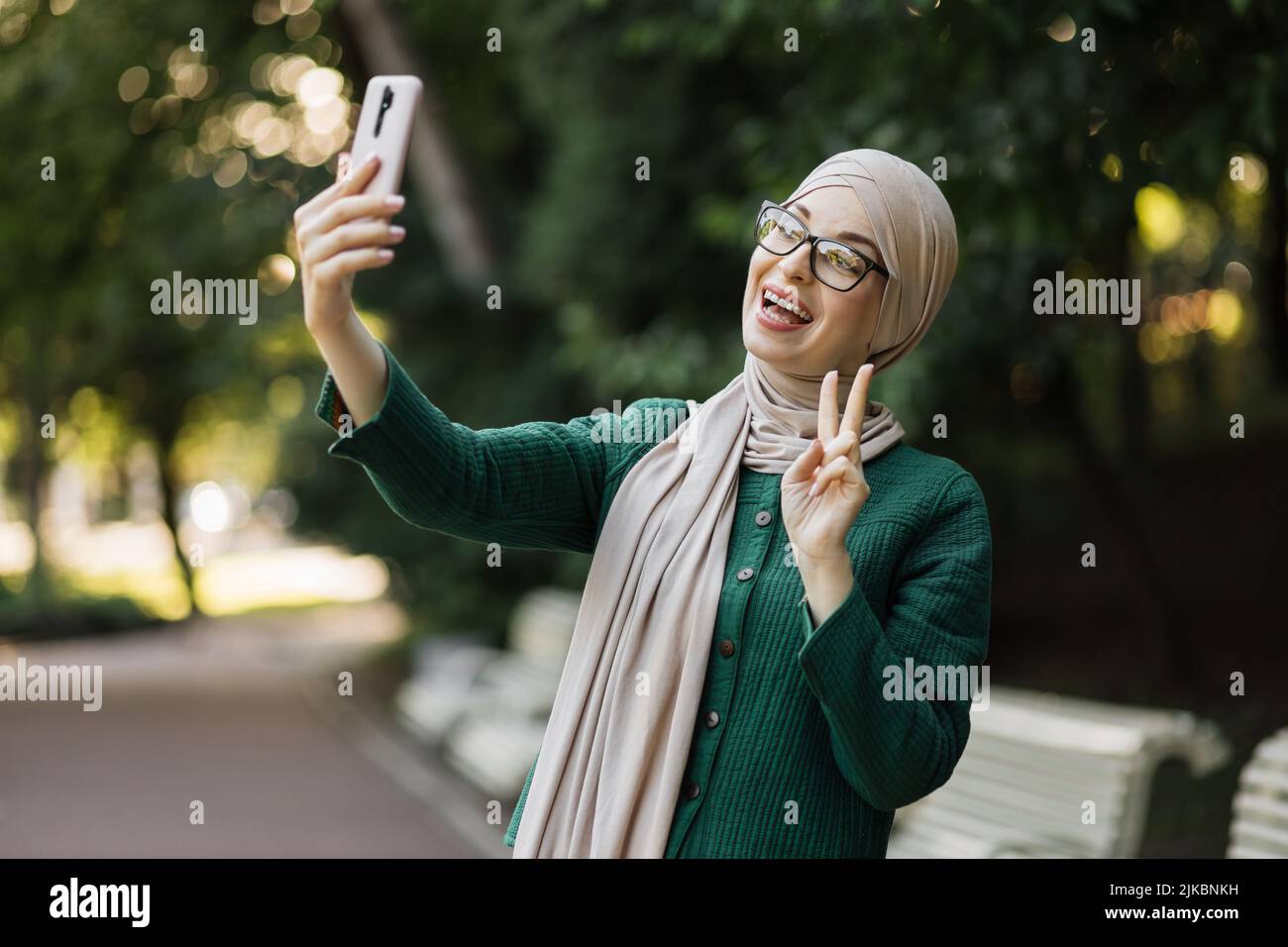 Portrait of smiling happy beautiful muslim woman relaxing using digital ...