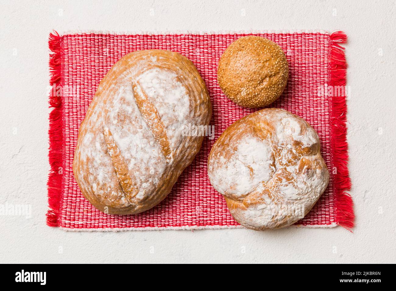 Assortment of freshly baked bread with napkin on rustic table top view