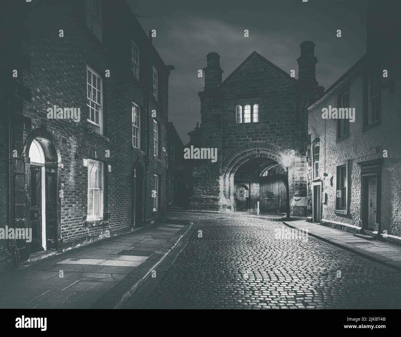 Abbey Gatehouse in Carlisle seen from the cobbled road of Abbey Street