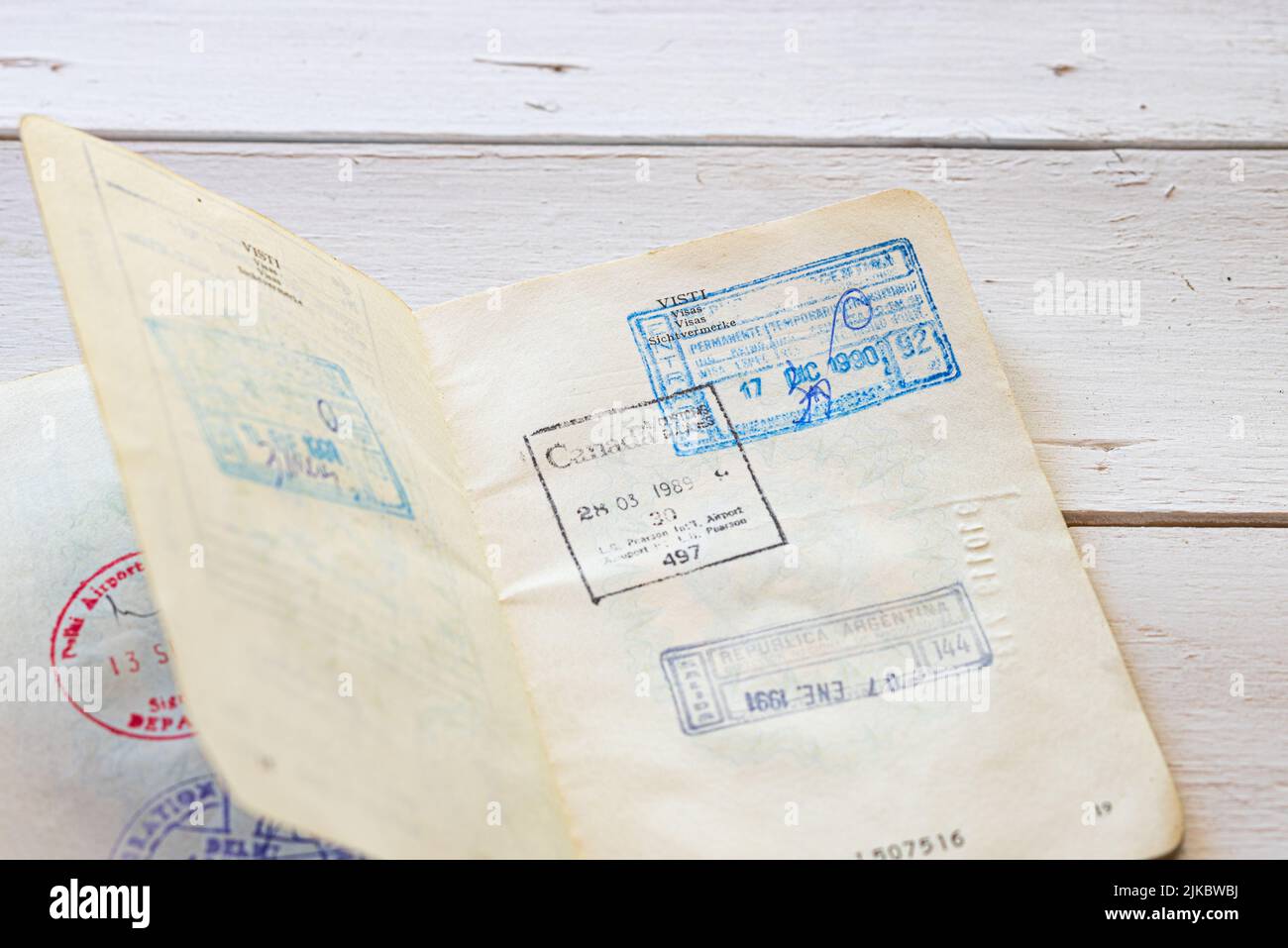 Old immigration stamps on passport. Immigration visas on an old Italian passport on a white