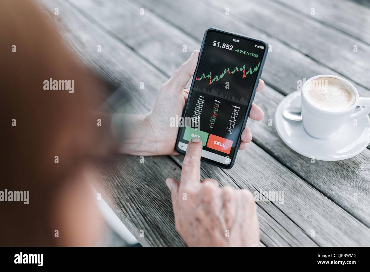 Senior woman using mobile phone application to buy cryptocurrency Stock Photo