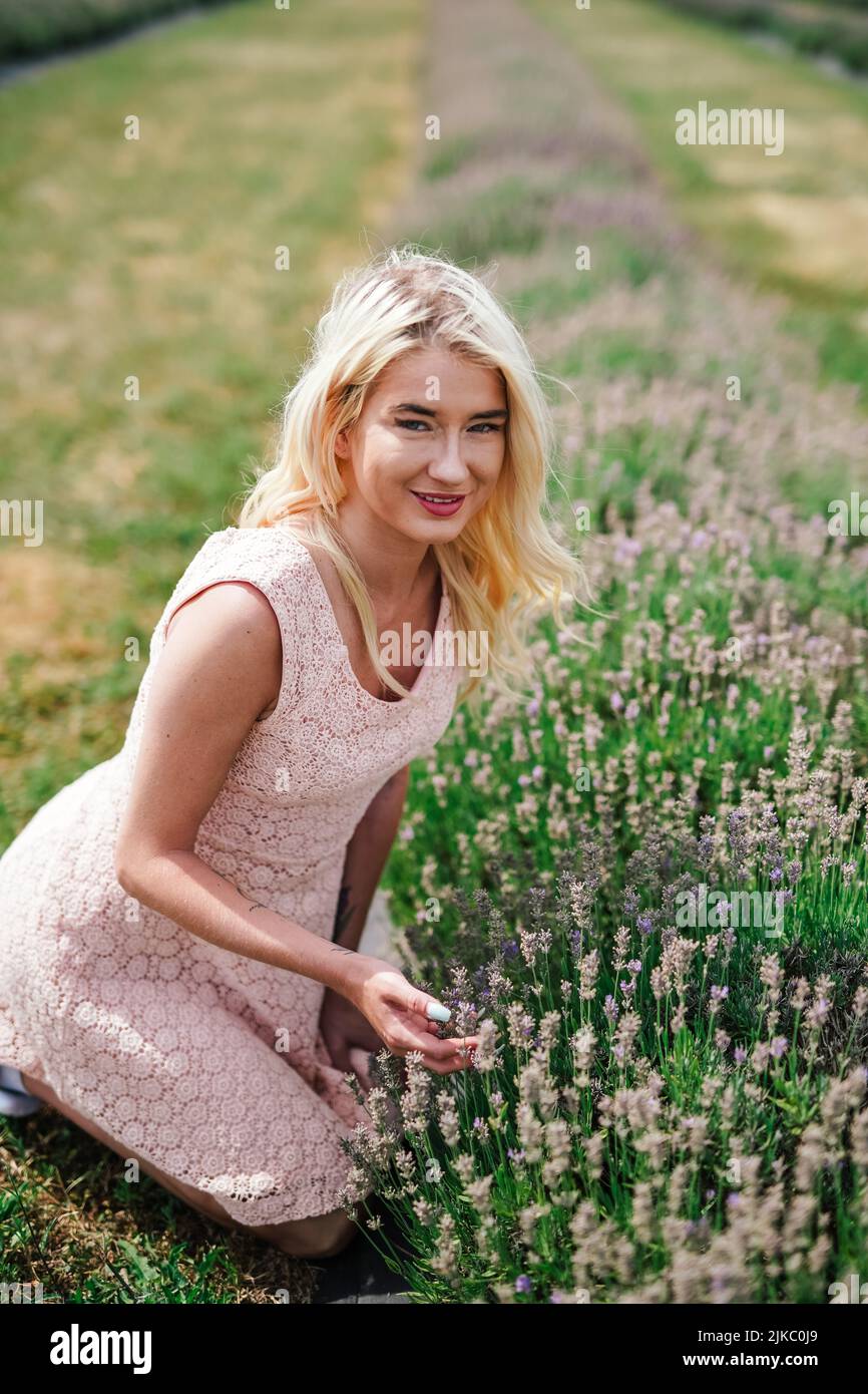 happy young female tourist visiting an outdoor lavender farm on a sunny summer day Stock Photo