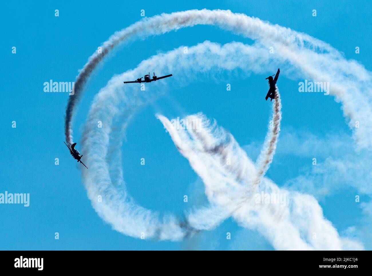 Silhouettes of training aircraft performing aerobatics on a clear sunny ...