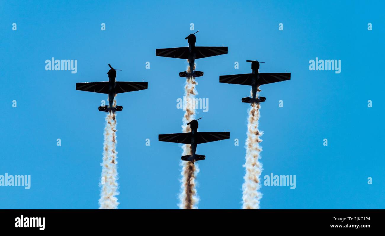 Silhouettes of training aircraft performing aerobatics on a clear sunny ...