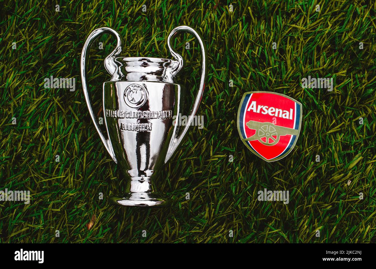 April 21, 2021, Moscow, Russia. The emblem of the football club Arsenal F.C. London and the UEFA Champions League Cup on the green grass of the stadiu Stock Photo