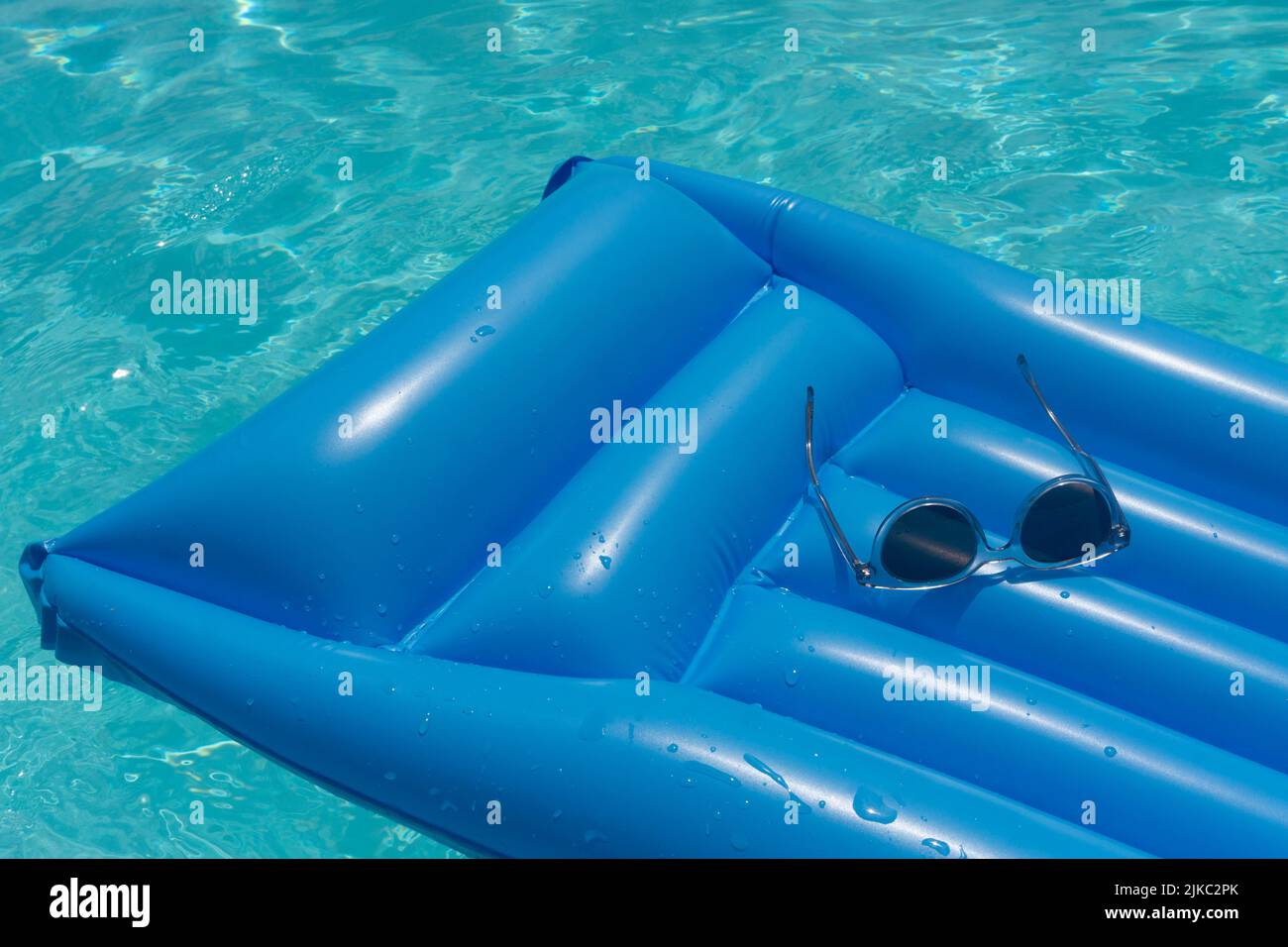 Sunglasses on a blue swimming pool float. Summer holiday background ...