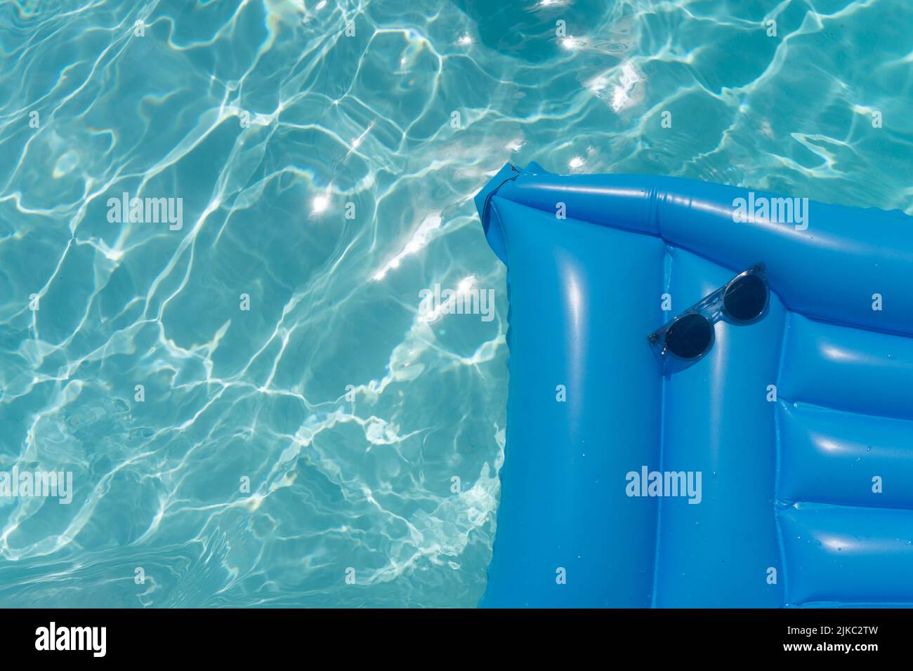 Sunglasses on a blue swimming pool float. Summer holiday background ...