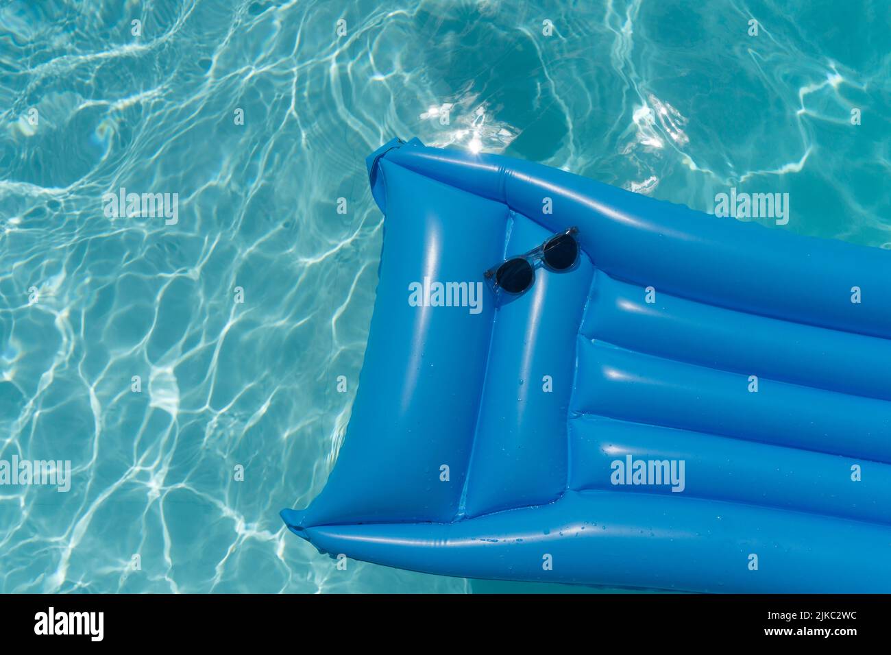 Sunglasses on a blue swimming pool float. Summer holiday background ...