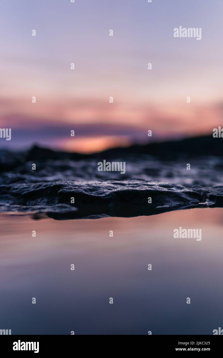 Waterside Rocks A shallow focus shot of waterside rocks at bright sunset Stock Photo ...