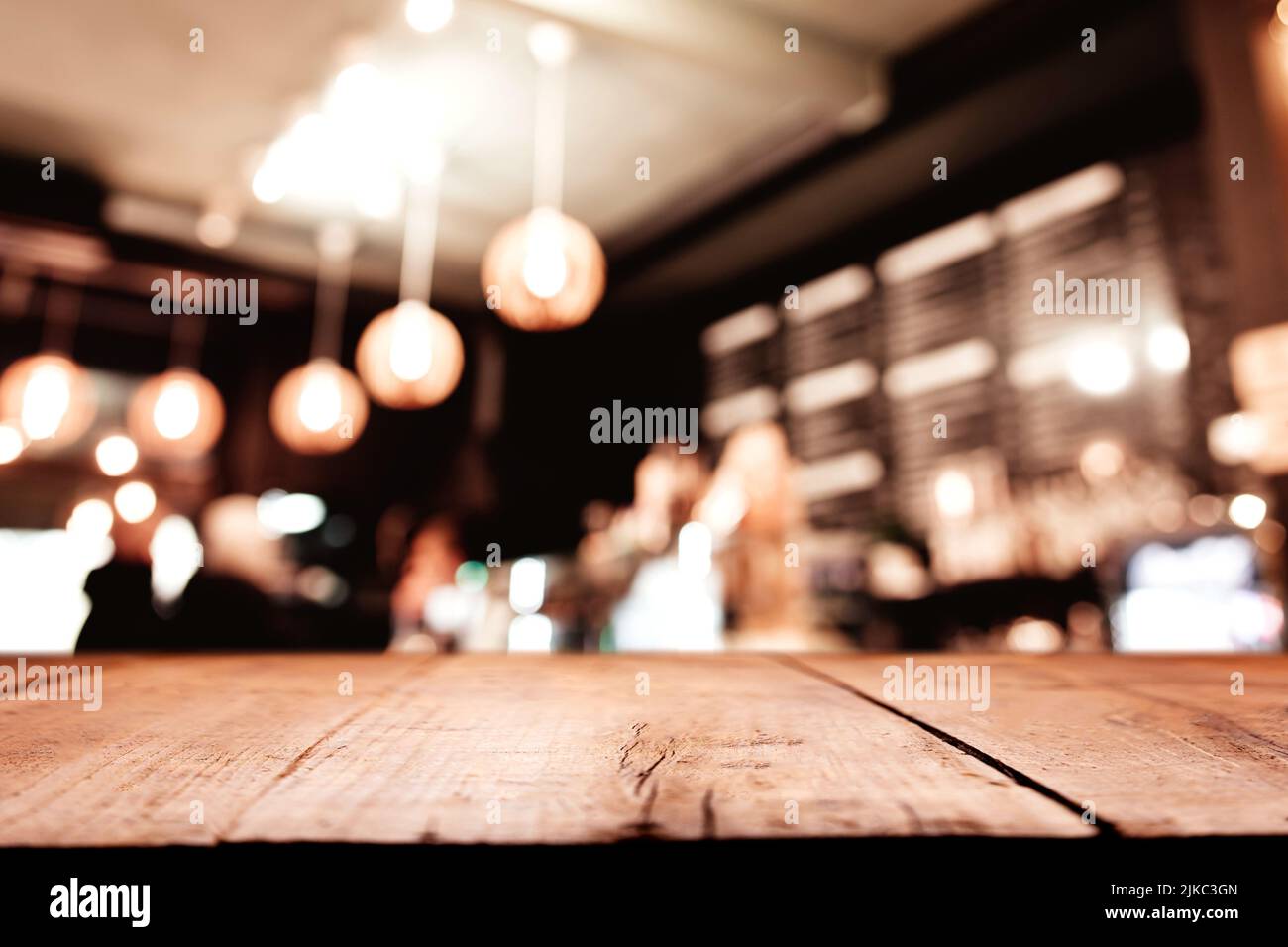 Empty blank wooden old deck table in front of abstract blurred festive background in bar, cafe, pub or restaurant with light spots and bokeh for product montage display of product. Copy space area Stock Photo