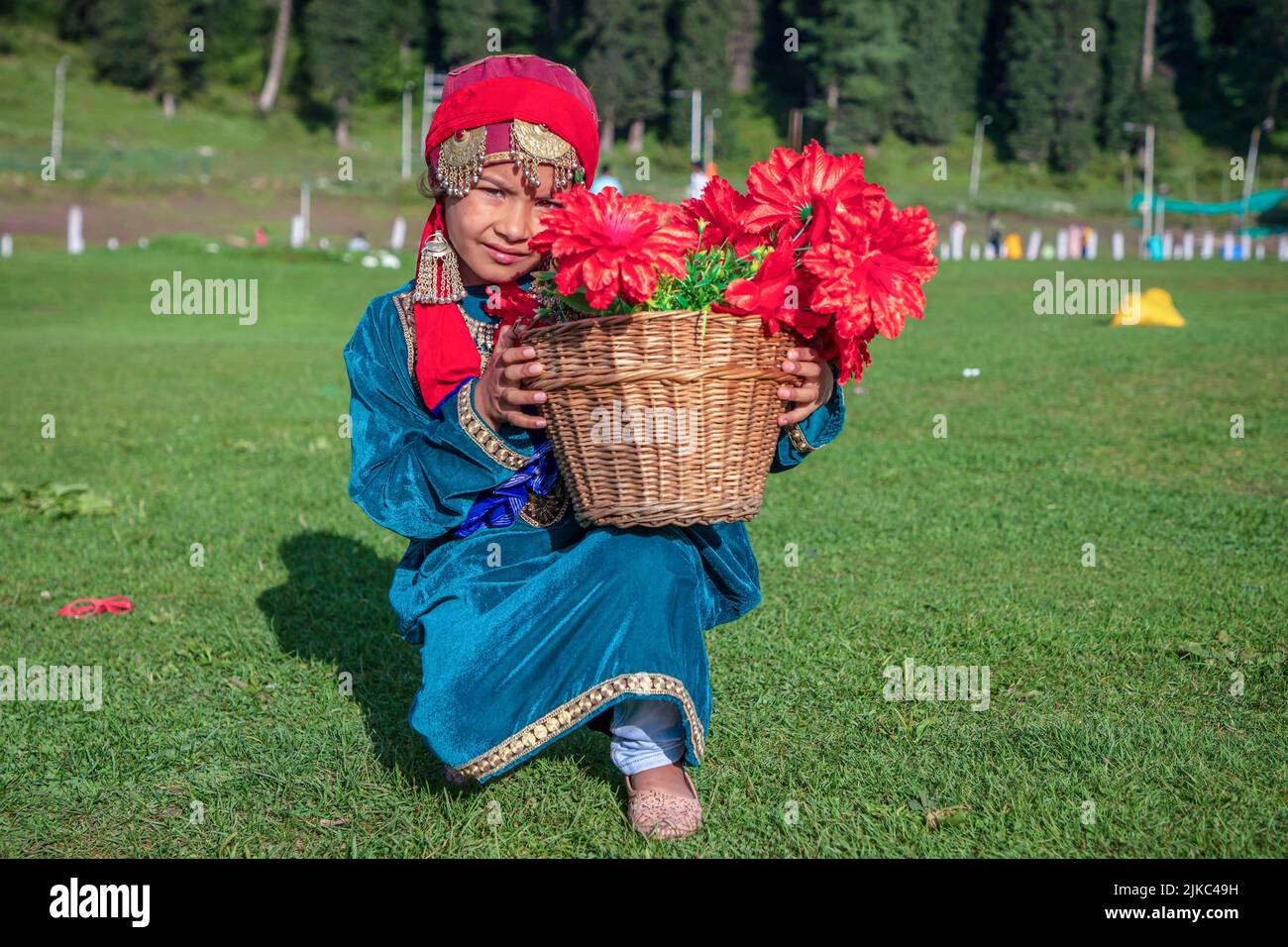 Srinagar, India. 30th July, 2022. A girl dressed in a traditional Kashmiri dress poses for a photo while holding a flower basket on a sunny day at famous tourist resort Gulmarg in Northern Kashmir's Baramulla district. Gulmarg is the crowning glory of Jammu & Kashmir and is located 2,650 meters above sea level. Known as the “Meadow of Flowers”, it boasts of the world's highest golf-course. (Photo by Faisal Bashir/SOPA Images/Sipa USA) Credit: Sipa USA/Alamy Live News Stock Photo