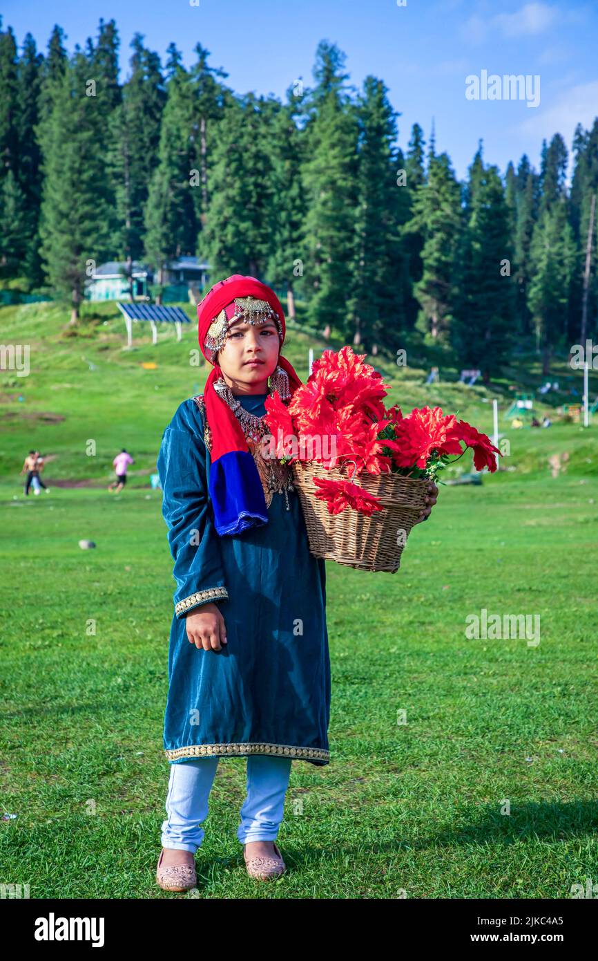Srinagar, India. 30th July, 2022. A girl dressed in a traditional Kashmiri dress poses for a photo while holding a flower basket on a sunny day at famous tourist resort Gulmarg in Northern Kashmir's Baramulla district. Gulmarg is the crowning glory of Jammu & Kashmir and is located 2,650 meters above sea level. Known as the “Meadow of Flowers”, it boasts of the world's highest golf-course. (Photo by Faisal Bashir/SOPA Images/Sipa USA) Credit: Sipa USA/Alamy Live News Stock Photo