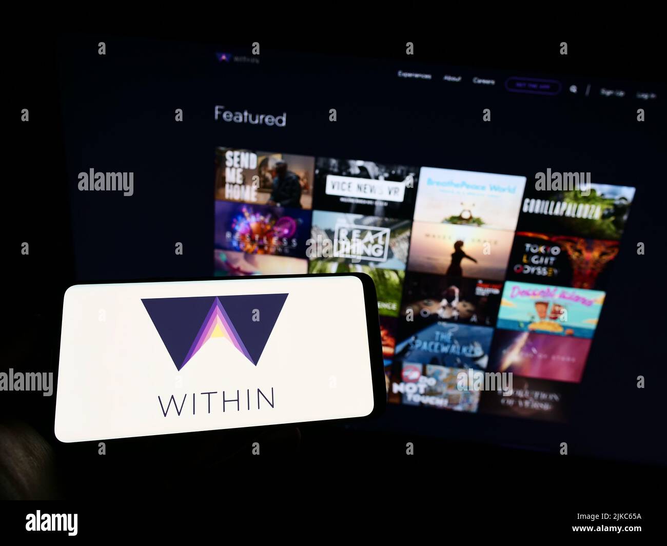 Person holding mobile phone with logo of virtual reality company Within