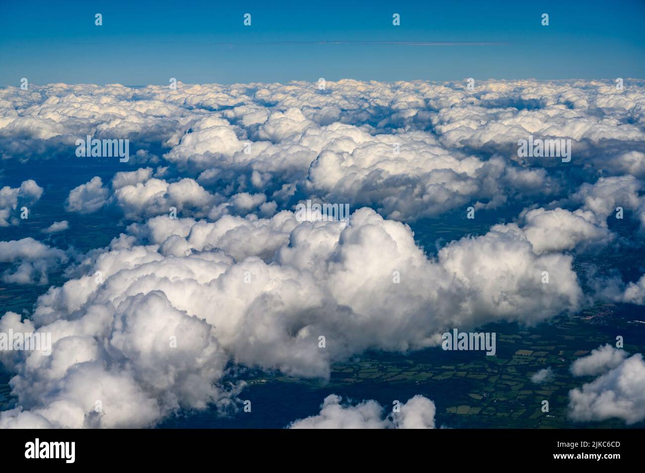 Aerial view over south coast of England from above white cumulus clouds photographed from a passenger jet. Stock Photo
