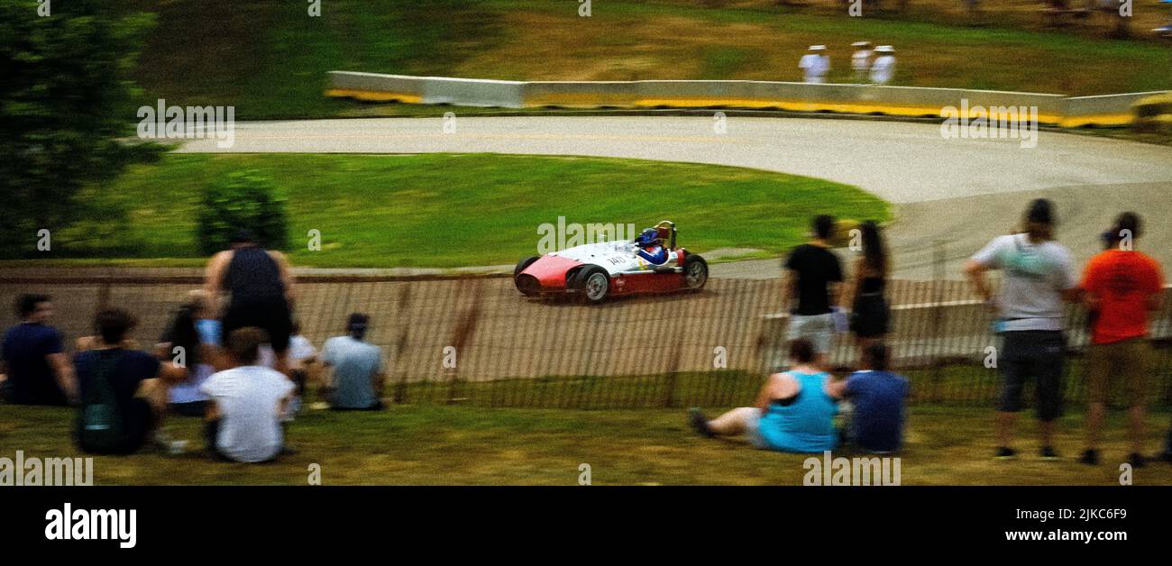 A classic car driving fast on a racing track at the Pittsburgh Vintage