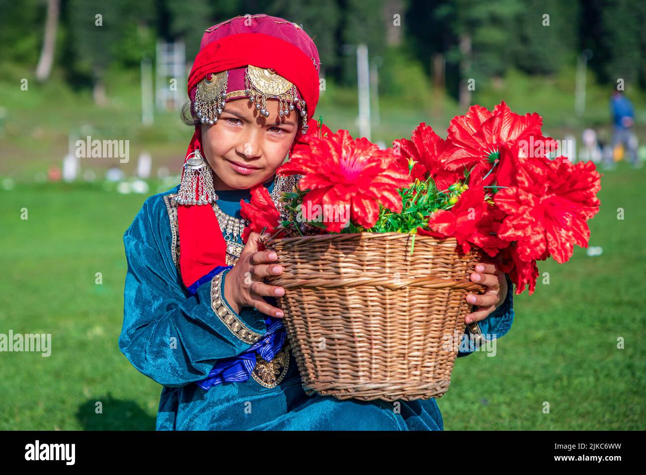 A girl dressed in a traditional Kashmiri dress poses for a photo while