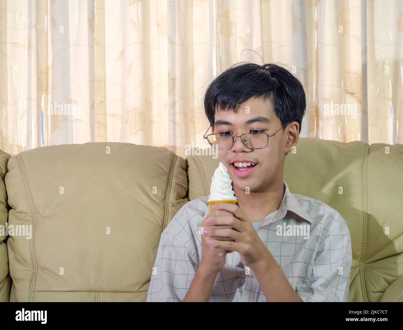 Asia boy kid hold vanilla ice cream in waffles cone happy smiling and eating deliciously in summer with have fun and good mood. Stock Photo