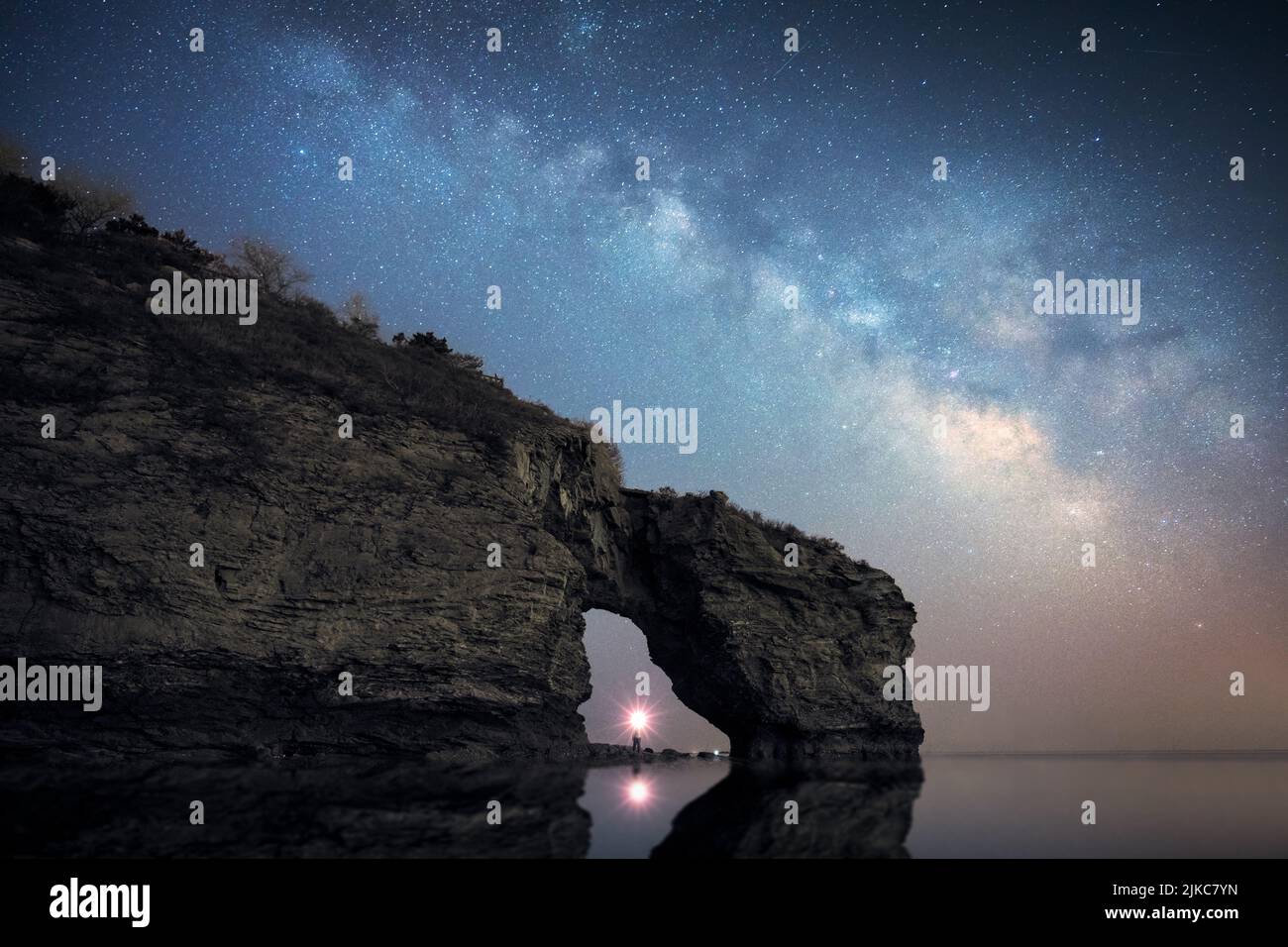 An aerial view of Durdle Door natural limestone arch on background of the blissful Milky Way in the sky Stock Photo