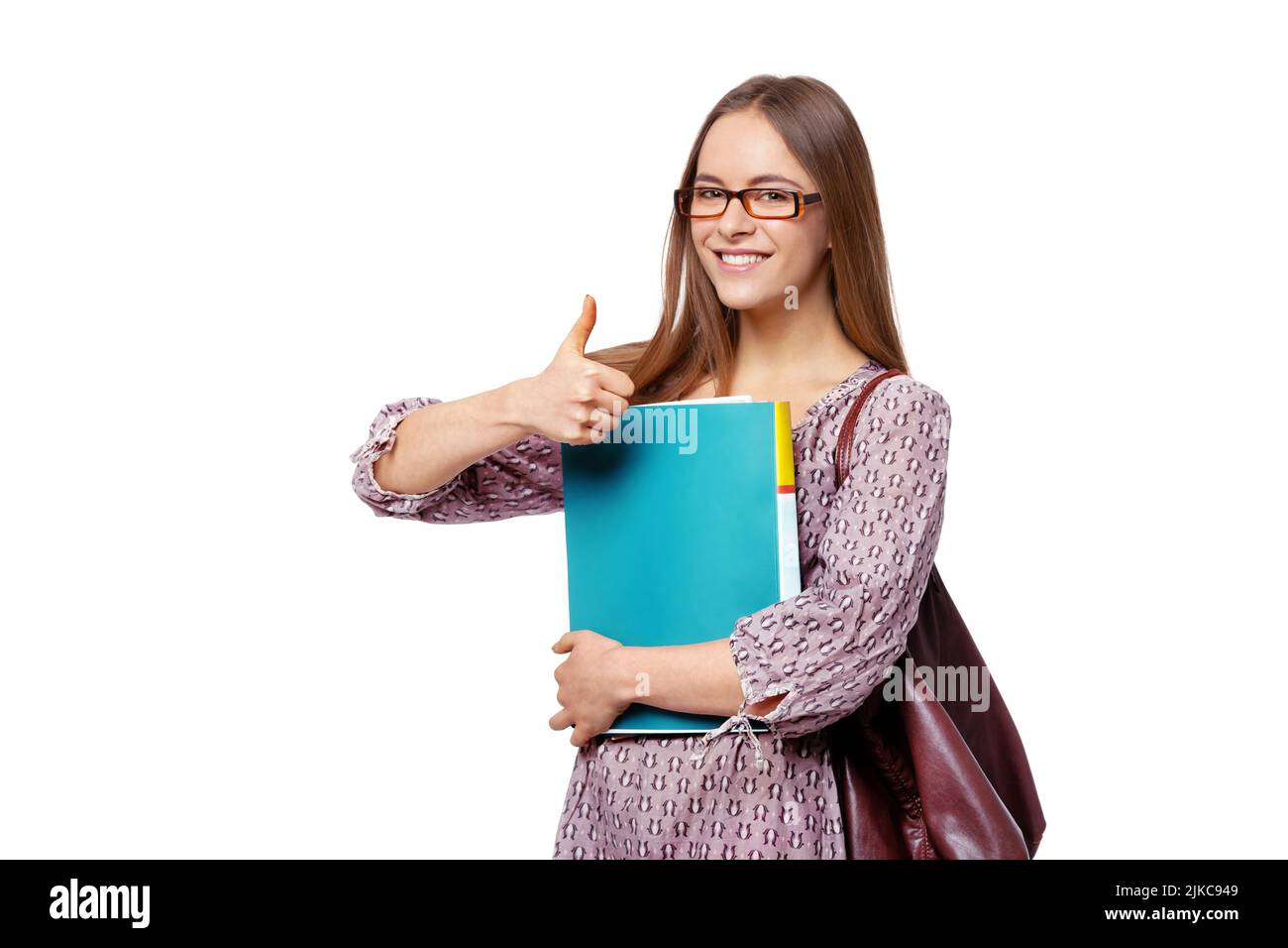 Beautiful female student with books showing thumb up isolated on white background. Stock Photo