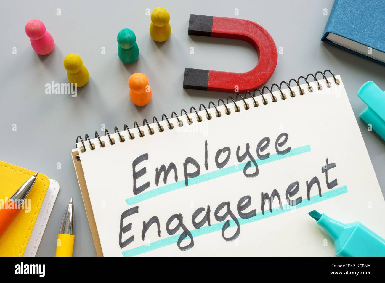 Phrase employee engagement near magnet and figurines. Stock Photo