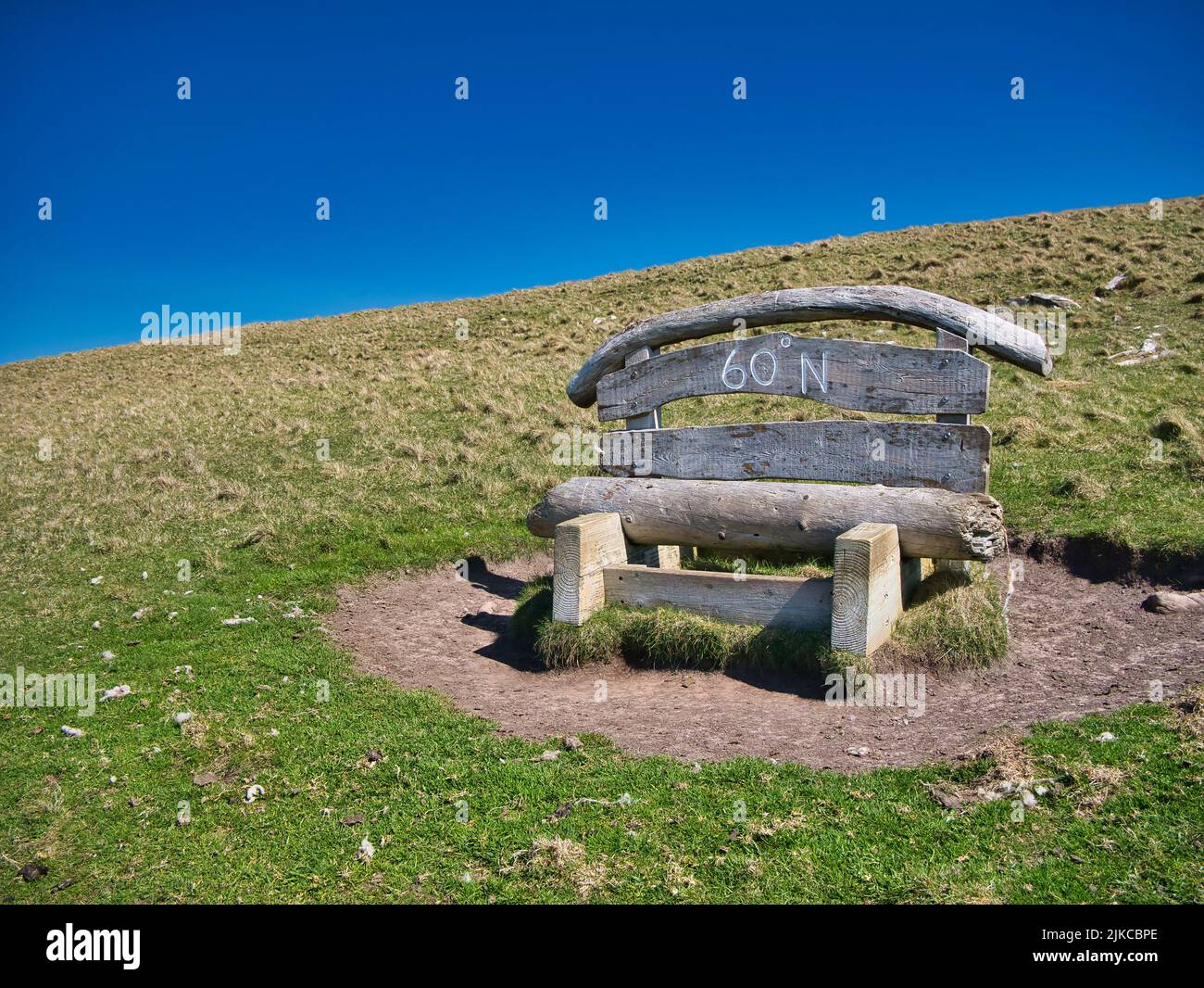 A wooden bench on the Island of Mousa, Shetland, UK marks the position of the 60 degree north parallel, which passes through the Islands. Stock Photo