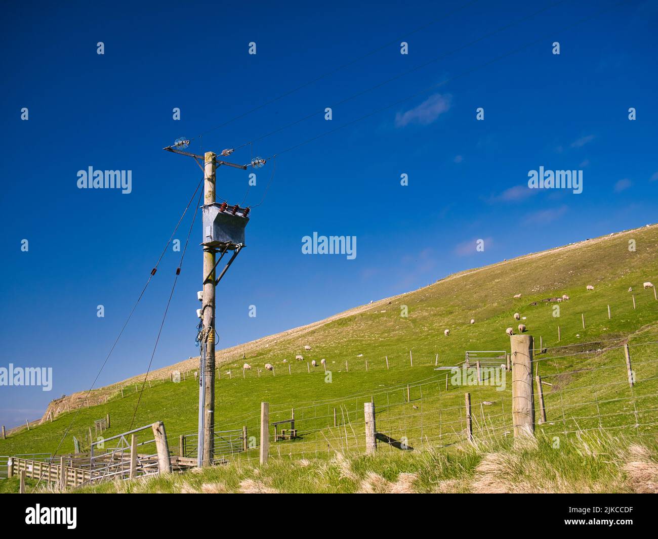 An electricity supply pylon delivering rural power through the UK national grid showing power cables, isolators and other equipment. Stock Photo