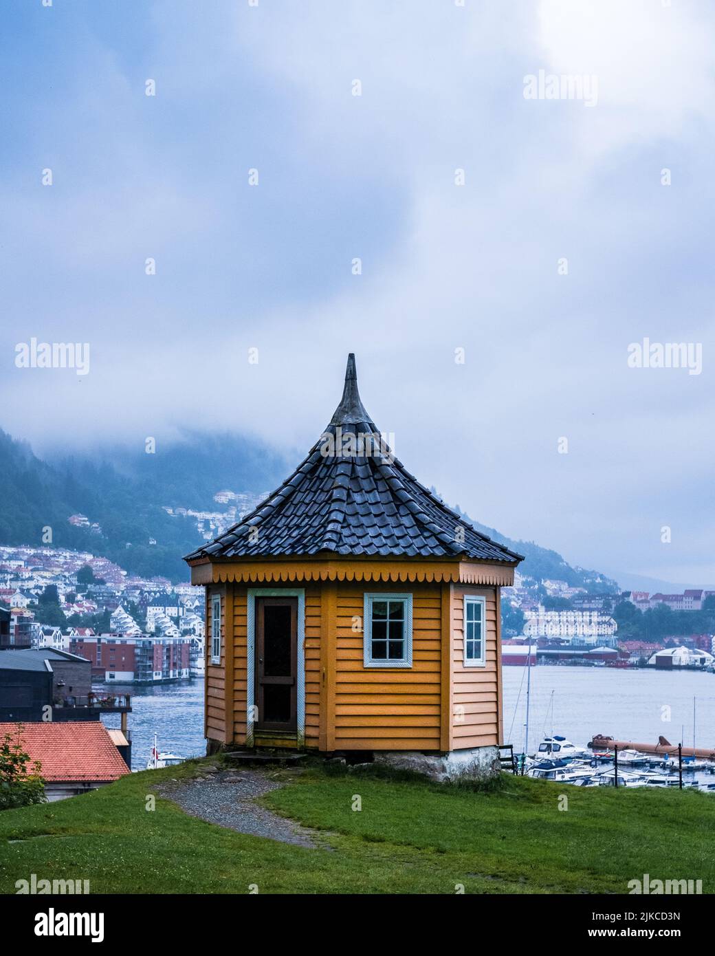A vertical shot of a beautiful gazebo with mountains in the background in Bergen, Norway Stock Photo
