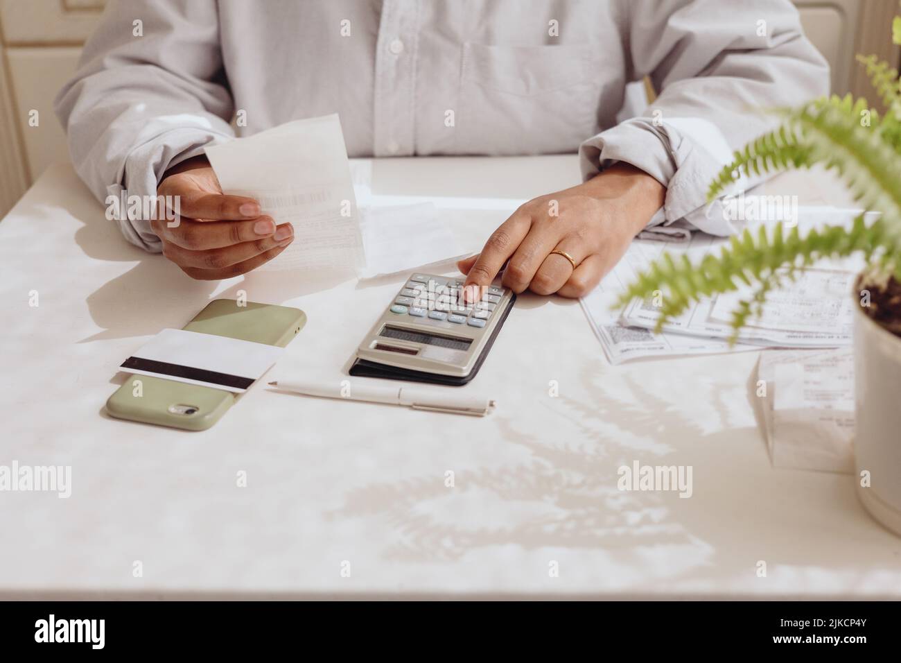 Top view of women's hands with a calculator and bills Stock Photo