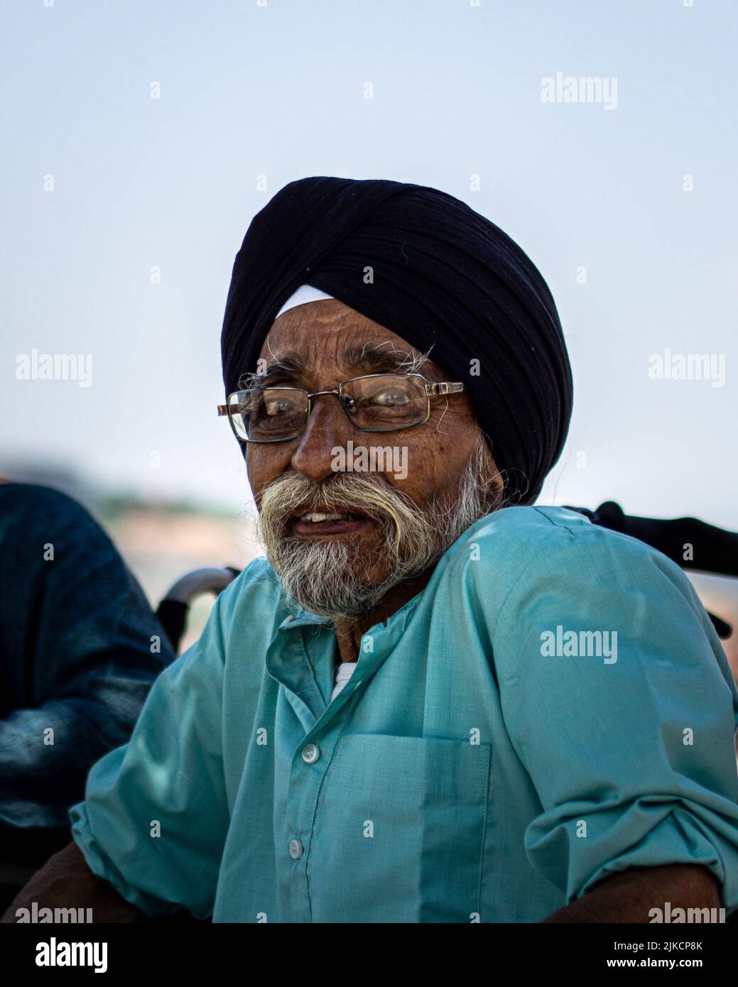 A vertical shot of senior Arab man in black headcover and glasses looking at the camera Stock Photo