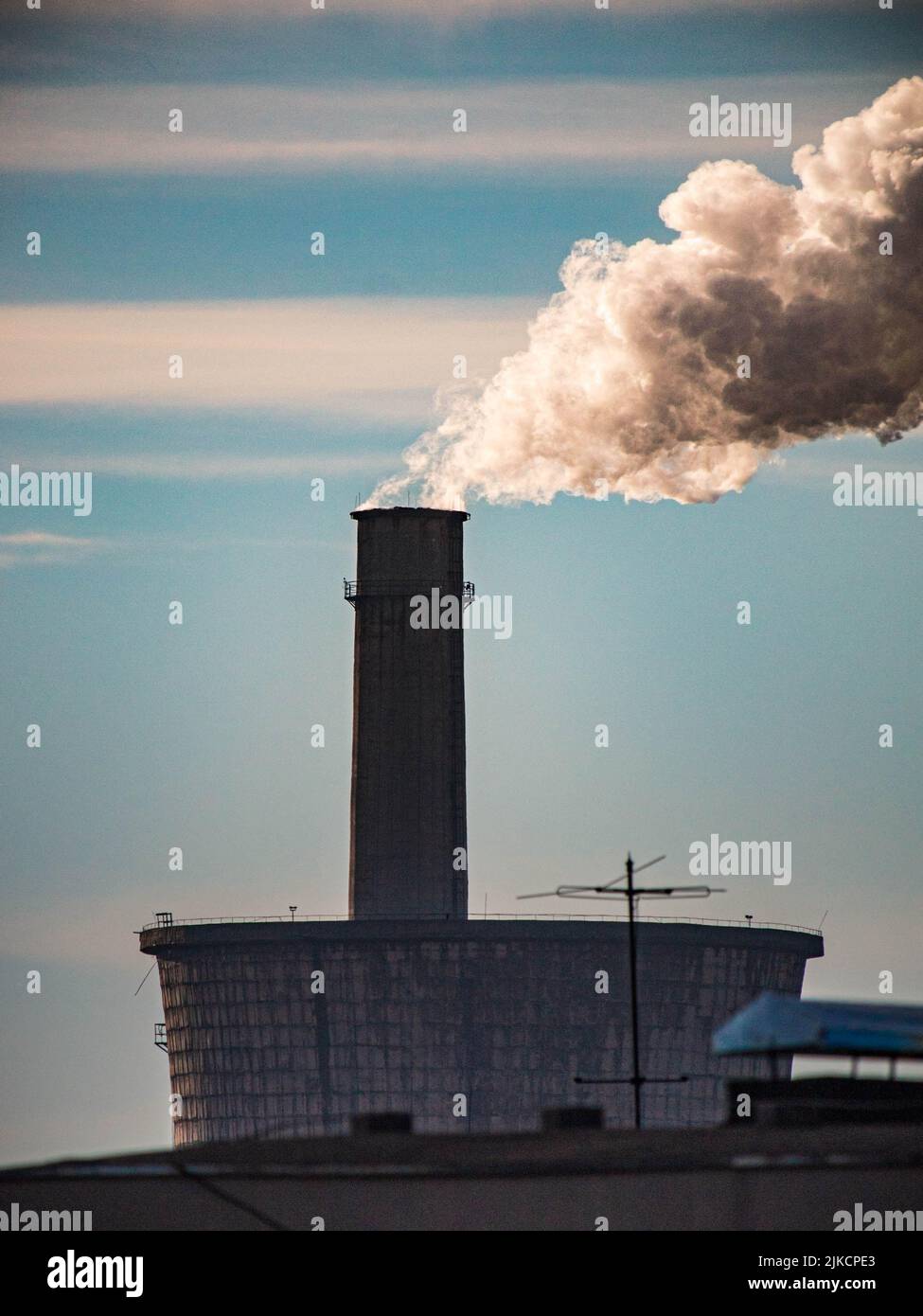 A dense smoke and steam coming out from the industrial chimney Stock Photo