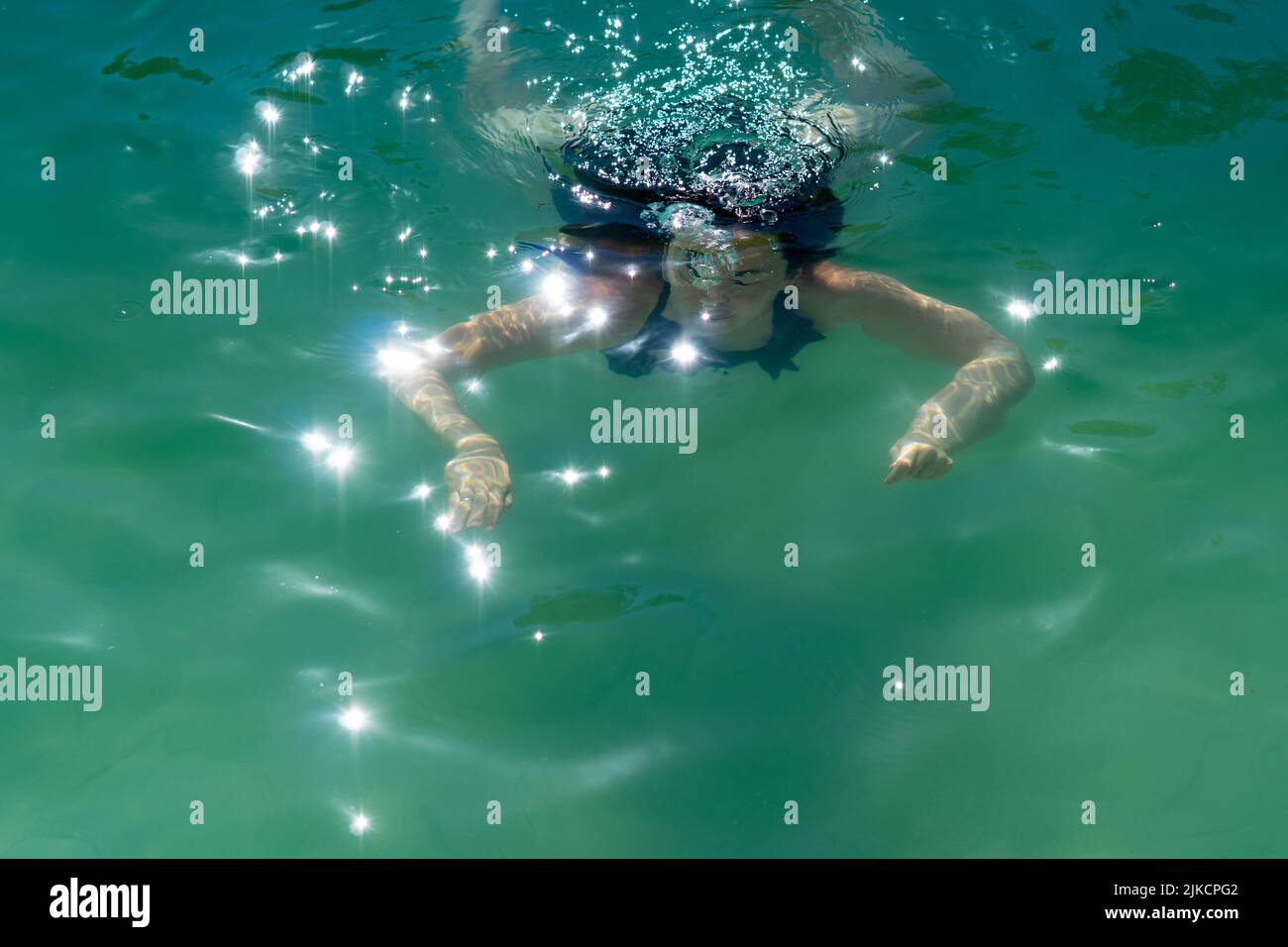 young girl diving in a lake coming out of the water Stock Photo
